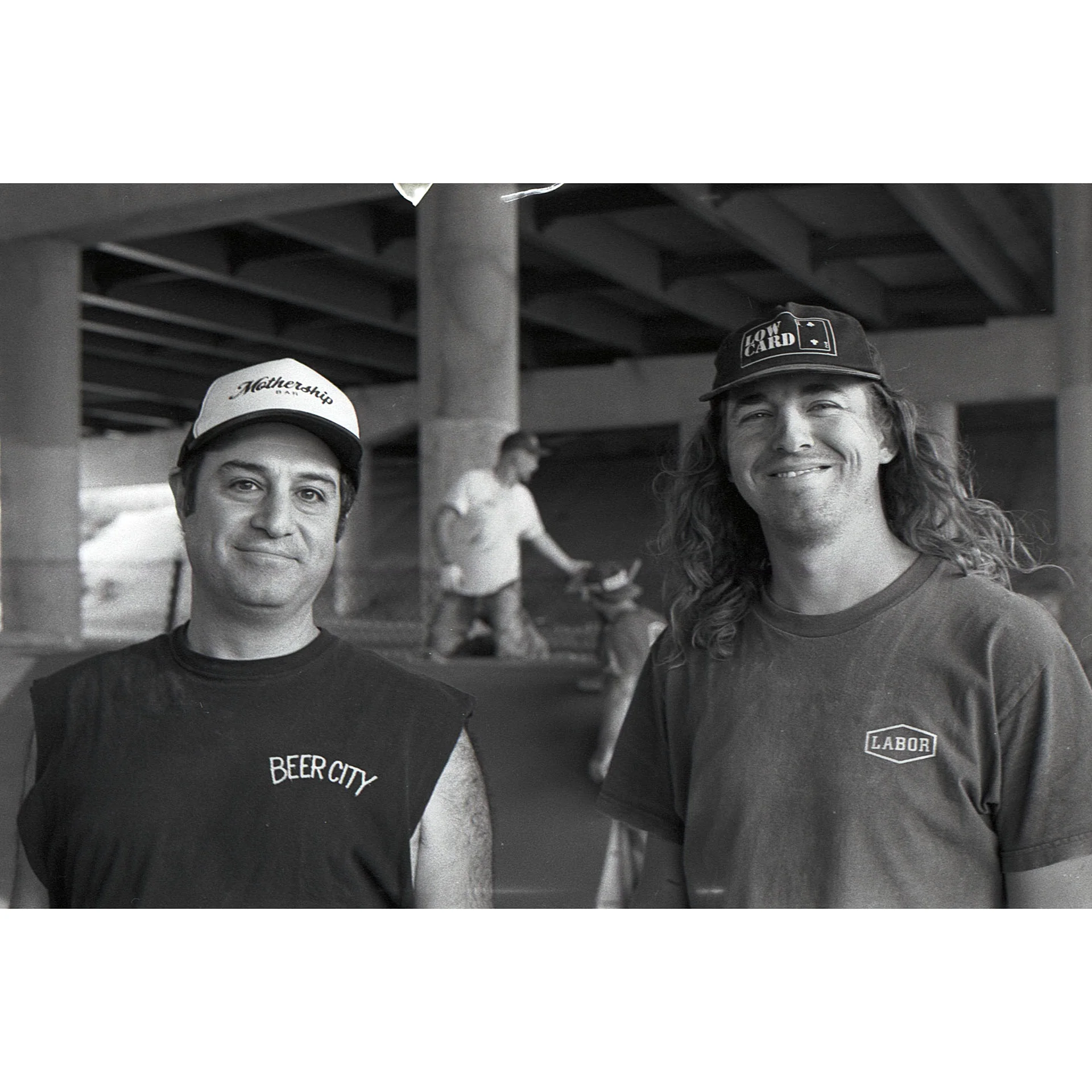 Black and white photo of Mike Beer and Mitch Schmidt smiling together during a build. Photo by Dylan Shanahan.